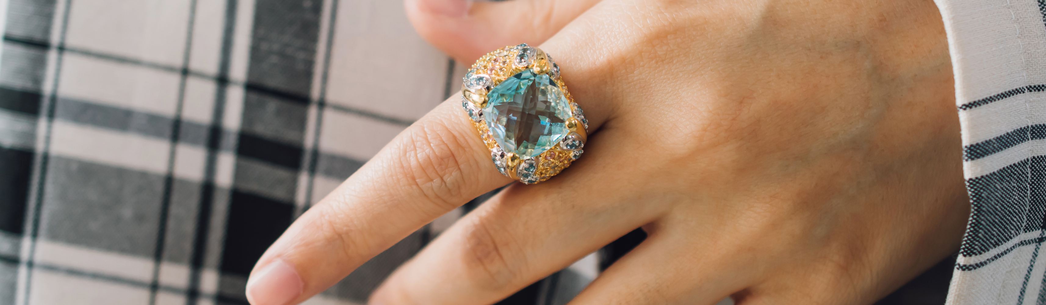 Woman wearing blue topaz ring, looks luxurious and elegant