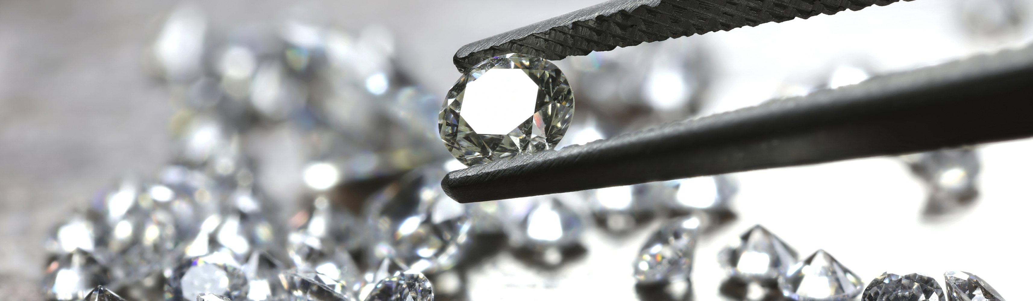 brilliant cut diamond held by tweezers