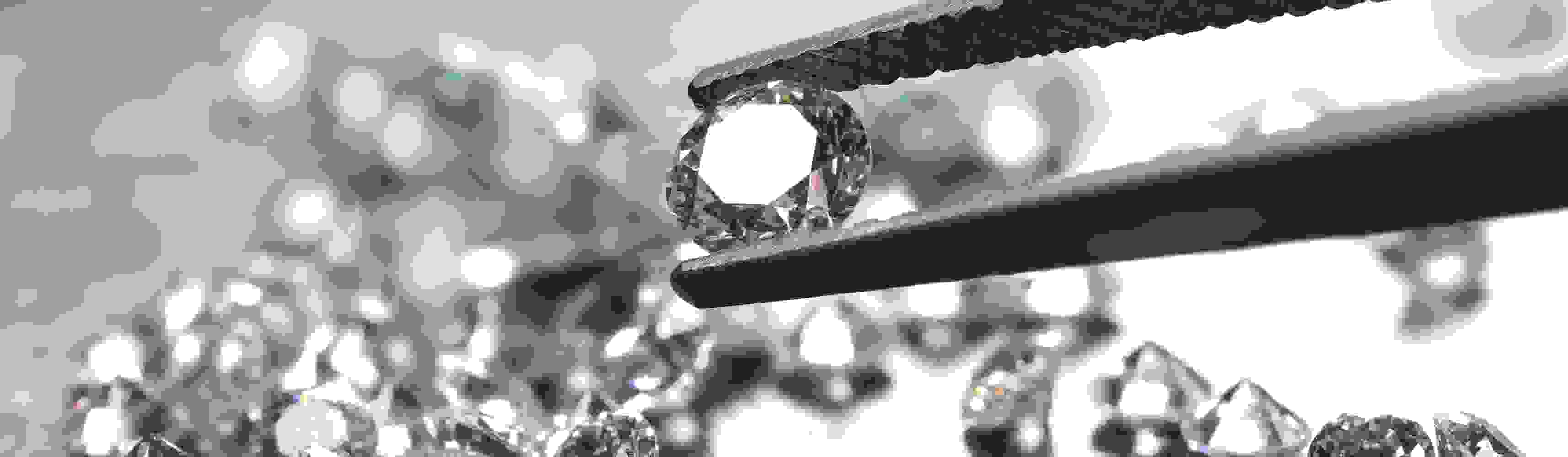 brilliant cut diamond held by tweezers