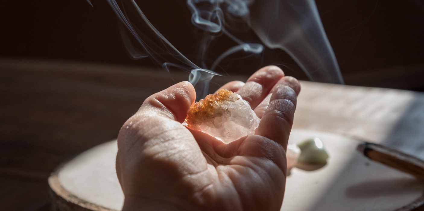 Young woman hand holding a citrine stone. Could be used for the meditation, energy healing, work with chakras or any other therapy