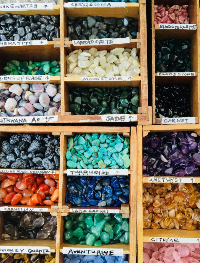 An assortment of different coloured gemstone in boxes